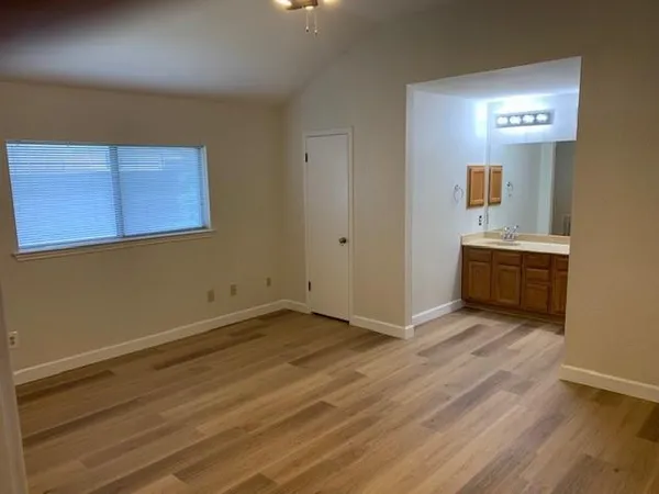 a spacious bathroom with a granite countertop sink toilet mirror and shower