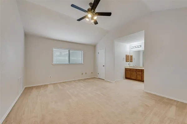an empty room with fan and windows