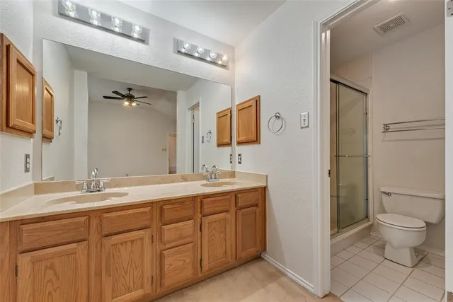 a spacious bathroom with a granite countertop sink toilet mirror and shower