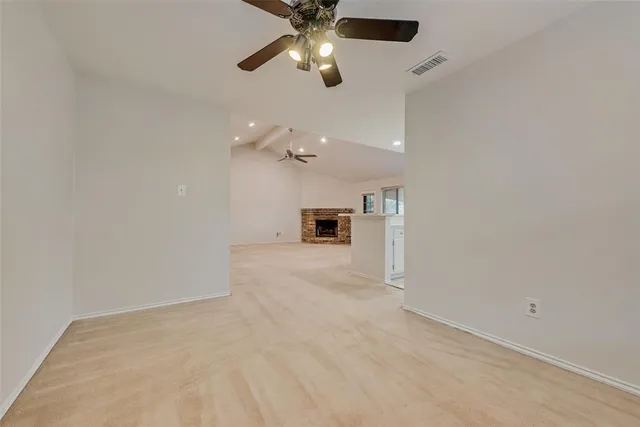 en empty room with ceiling fan and window