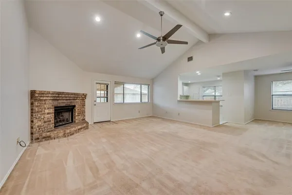 a view of an empty room with a fireplace and a window
