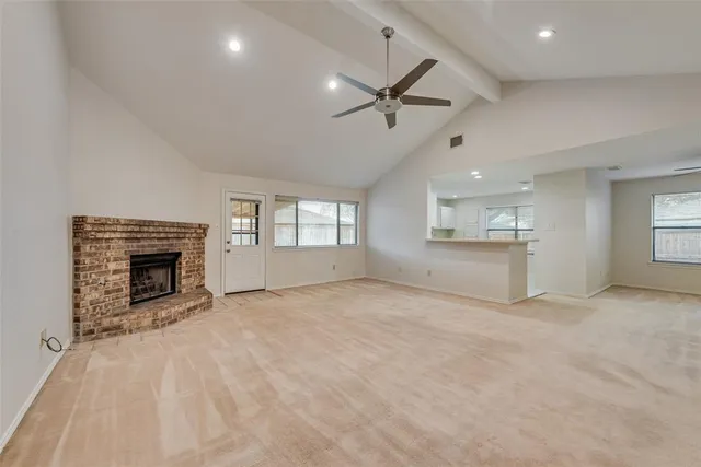 a view of an empty room with a fireplace and a window