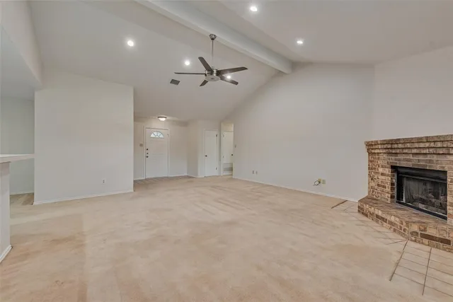 an empty room with fireplace and fan