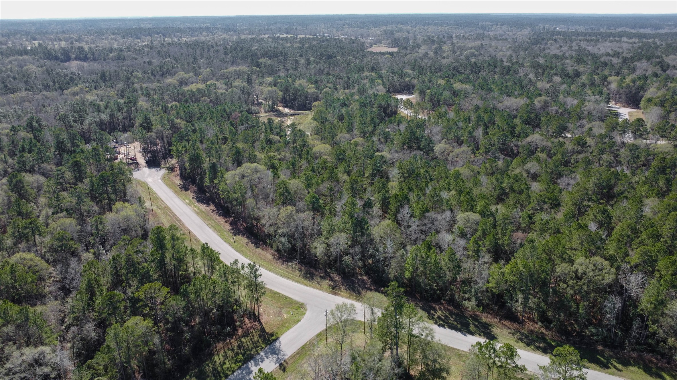 0 Bighorn Road Huntsville, TX 77340 - Photo 9 of 22 Soaring high above the community, this wide-angle aerial shot reveals the property’s strategic location at the curve of Bighorn Road, surrounded by towering pines, distant homesites, and unspoiled landscape. A perfect balance of privacy and accessibility.