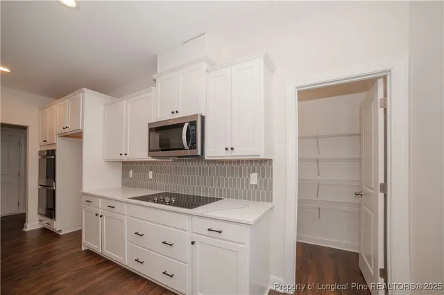 a kitchen with white cabinets and stainless steel appliances