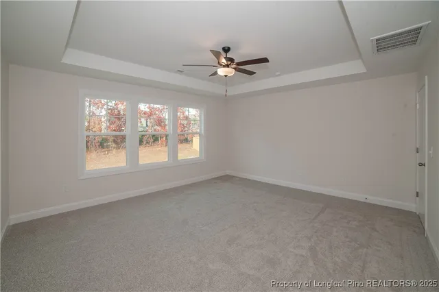 an empty room with a window and ceiling fan