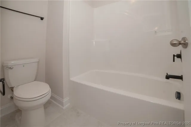 a white bath tub sitting next to a toilet