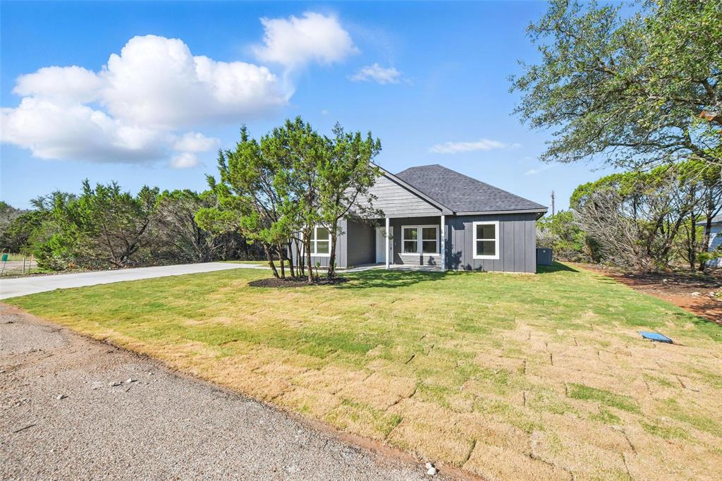 112 Cedar Shadow Lane Whitney, TX 76692 - Photo 3 of 28 a front view of house with yard and trees in the background