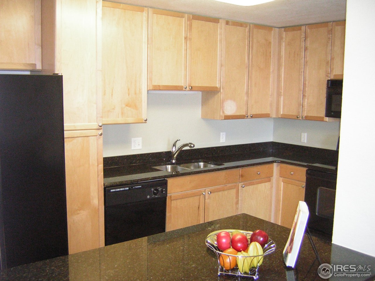 4500 Baseline Road, Unit 2207 Boulder, CO 80303 - Photo 14 of 16 a kitchen with granite countertop a stove a sink and a microwave