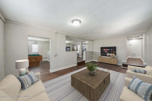 a living room with furniture and a wooden floor