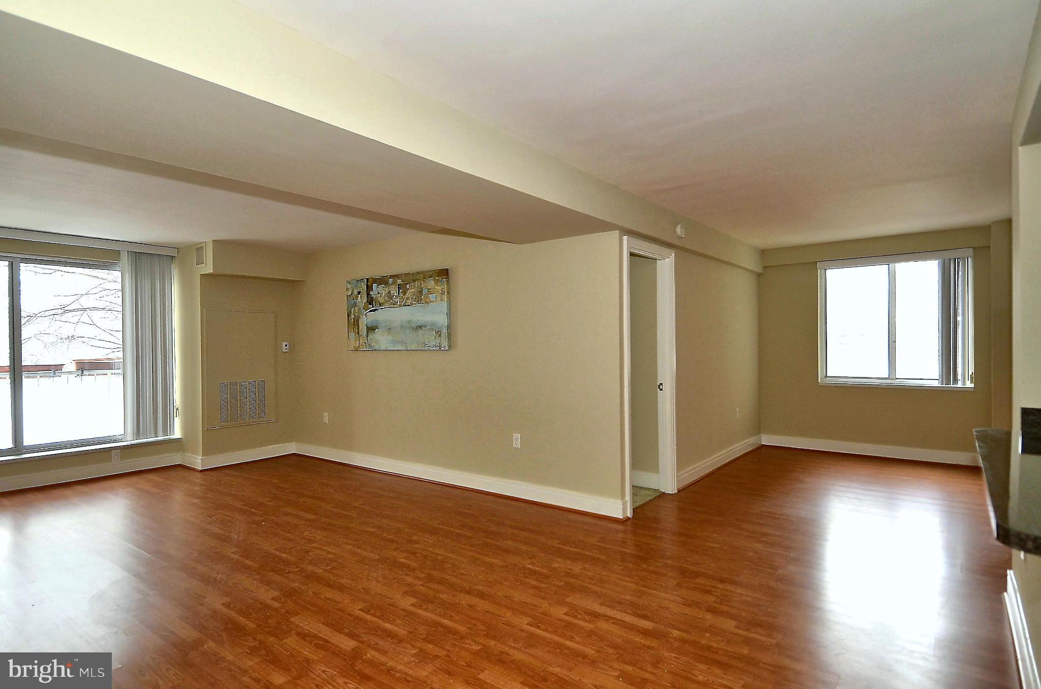 800 4th Street Southwest, Unit N201 Washington, DC 20024 - Photo 10 of 25 an empty room with wooden floor and windows