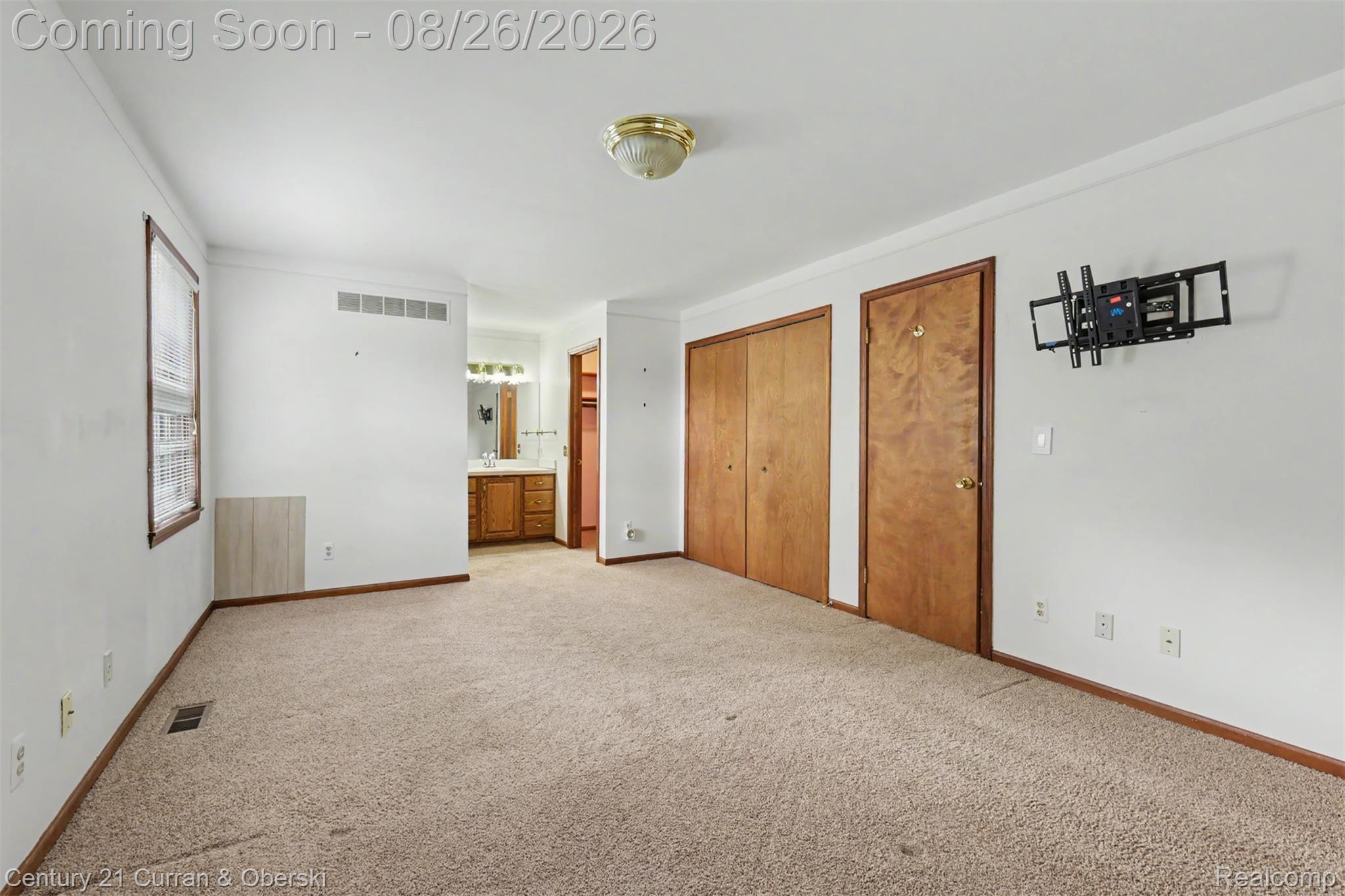 18227 Meridian Road Grosse Ile, MI 48138 - Photo 15 of 23 Carpeted room featuring multiple windows, recessed vanity area, and two solid wood doors