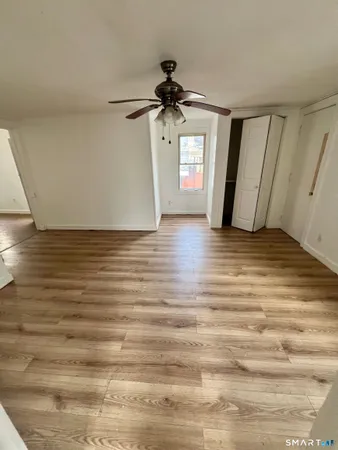 a view of a livingroom with wooden floor and a ceiling fan