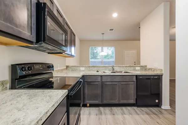 a kitchen with stainless steel appliances granite countertop a sink and stove top oven