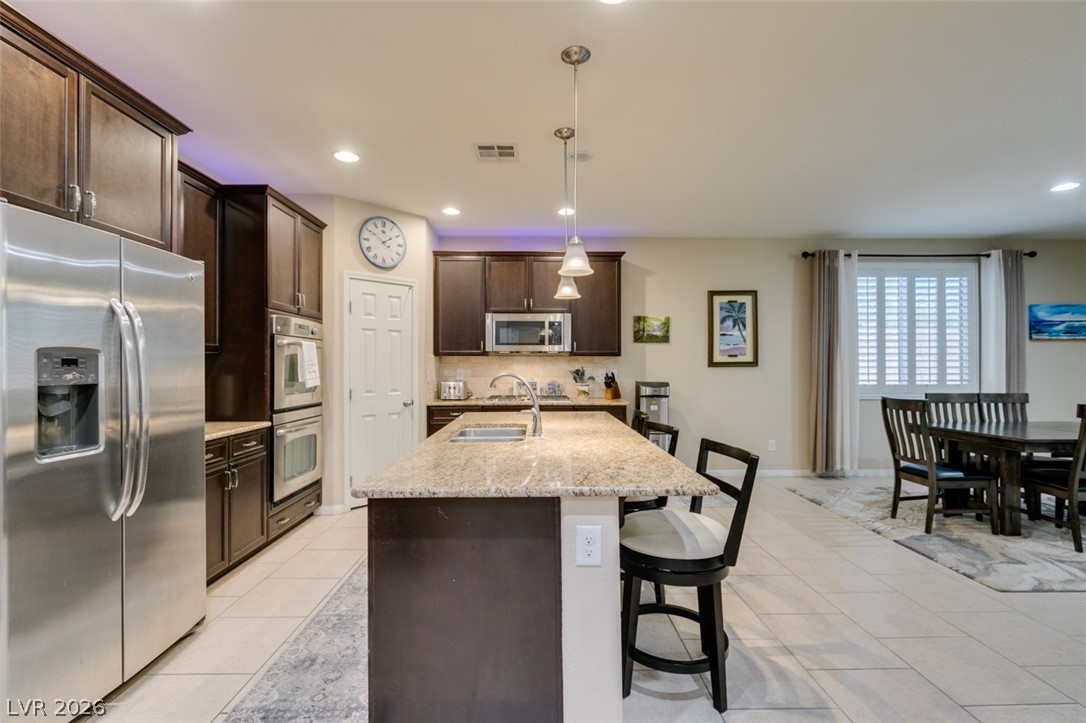7375 Campbell Ranch Avenue Las Vegas, NV 89179 - Photo 12 of 45 Culinary adventures await in this kitchen, boasting an expansive island with granite counters and stainless steel appliances.