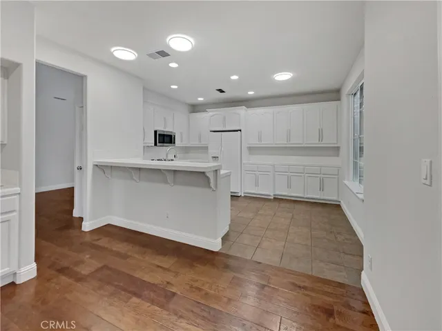 a view of kitchen with wooden floor and electronic appliances