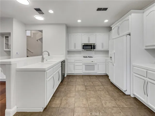 a kitchen with kitchen island sink stove and refrigerator