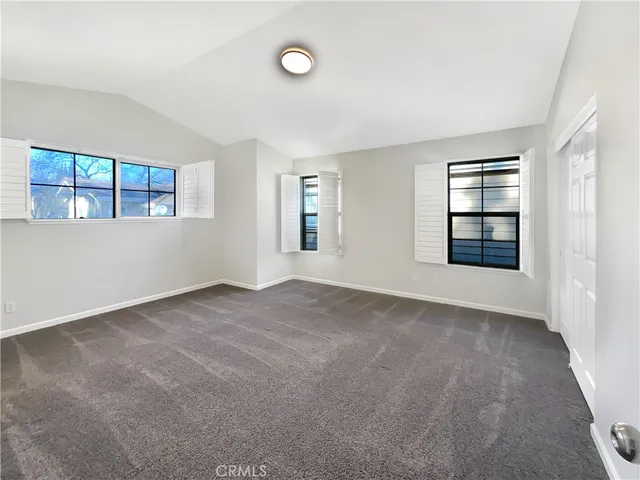 an empty room with windows and ceiling fan