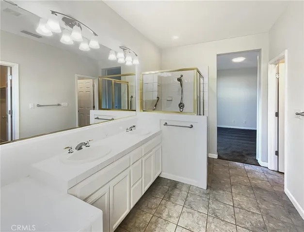 a spacious bathroom with a double vanity sink and a mirror