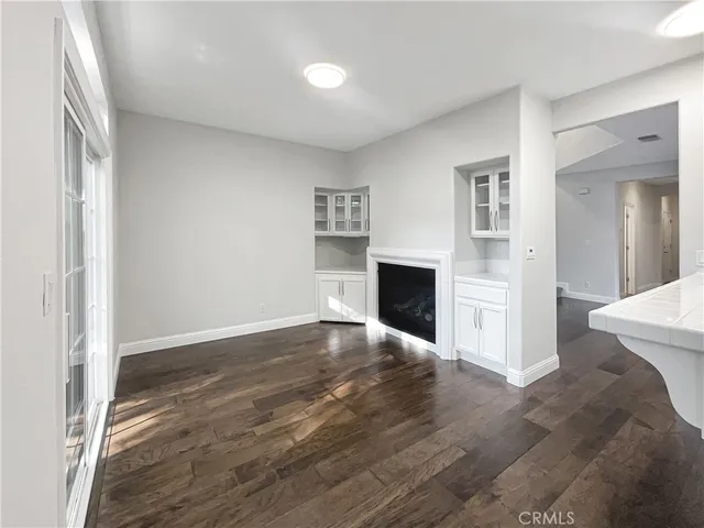 a view of empty room with wooden floor and fireplace
