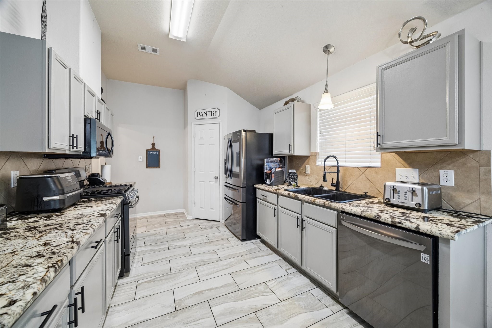 4830 Conifer Ridge Way Humble, TX 77346 - Photo 3 of 16 a kitchen with stainless steel appliances granite countertop a sink a stove and a refrigerator