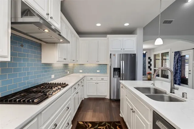 a kitchen with white cabinets and appliances