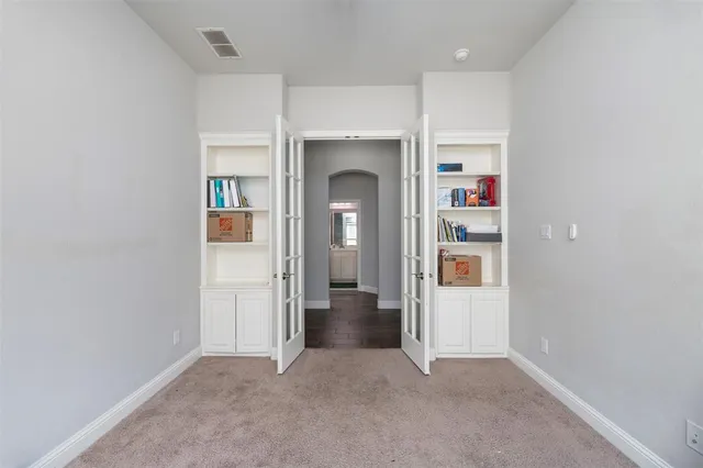 an empty room with closet and windows
