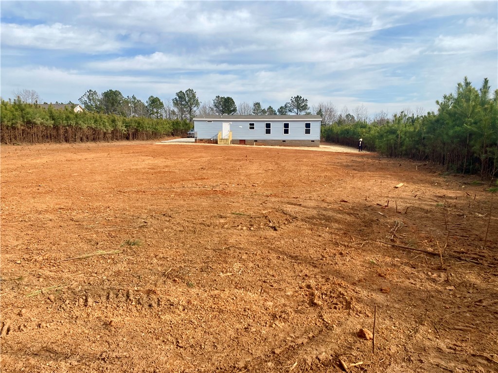 384 Skippers Lodge Road Cross Hill, SC 29332 - Photo 31 of 47 Expansive lot ready for development, framed by natural greenery.