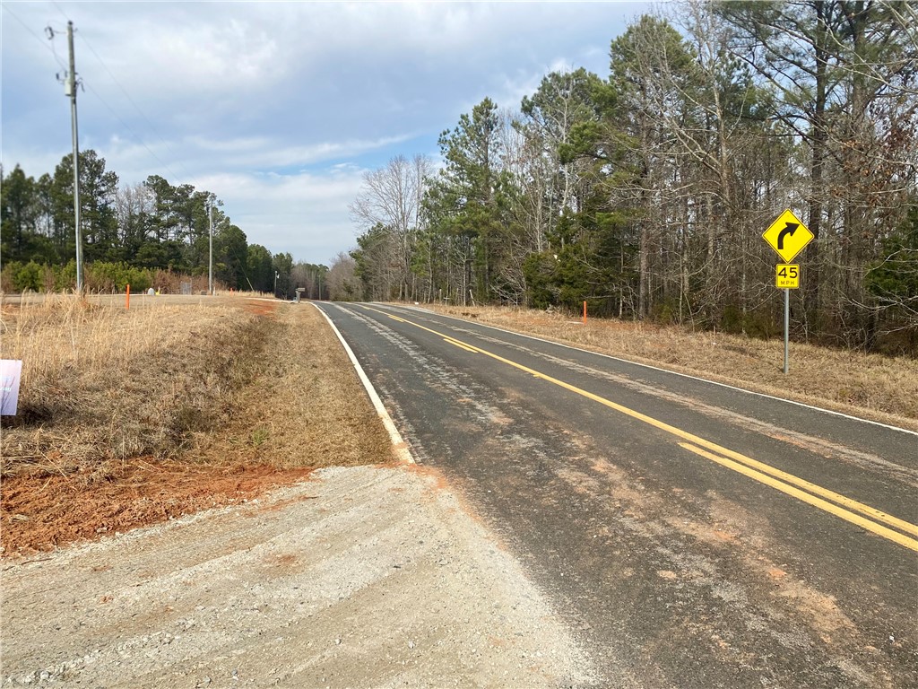 384 Skippers Lodge Road Cross Hill, SC 29332 - Photo 37 of 47 A winding road traverses a wooded landscape under an expansive sky.