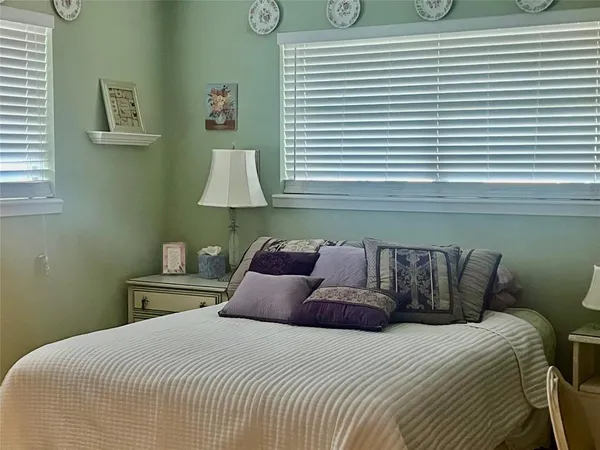 a large bed sitting in a bedroom next to a window