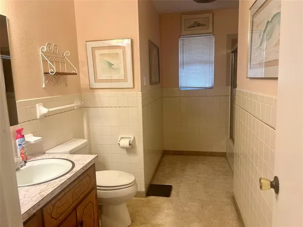 a bathroom with a granite countertop toilet sink and mirror