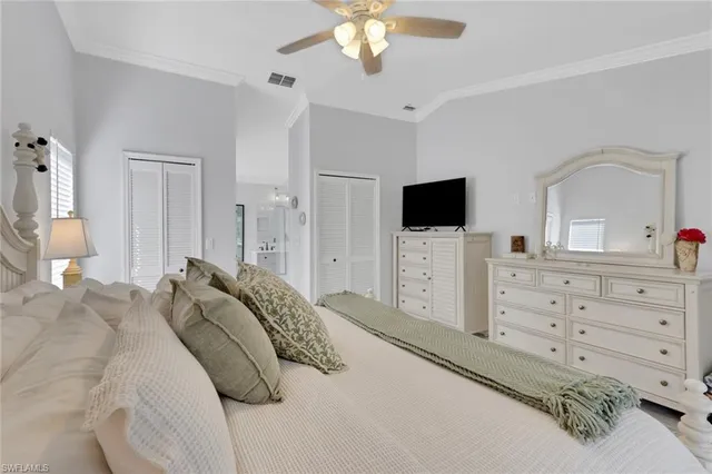 a bedroom with a bed a tv and cabinets