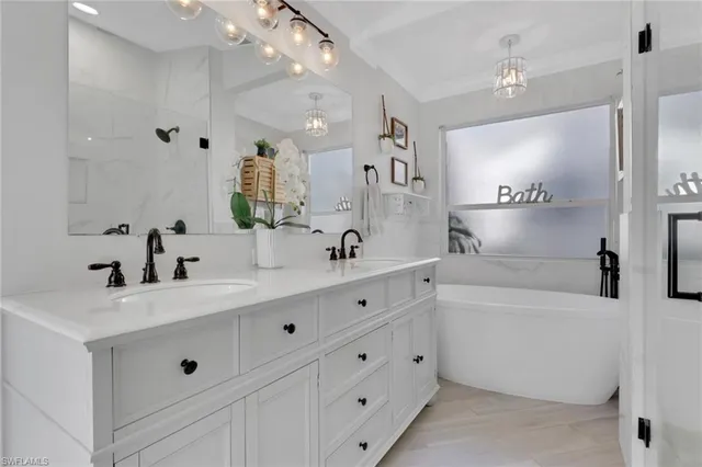 a bathroom with double vanity sink a mirror and a bathtub