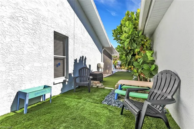 a view of a chair and table in backyard of the house