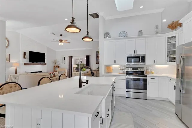 a kitchen with stainless steel appliances a stove a sink and a microwave