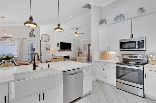 a kitchen with a sink a stove and white cabinets