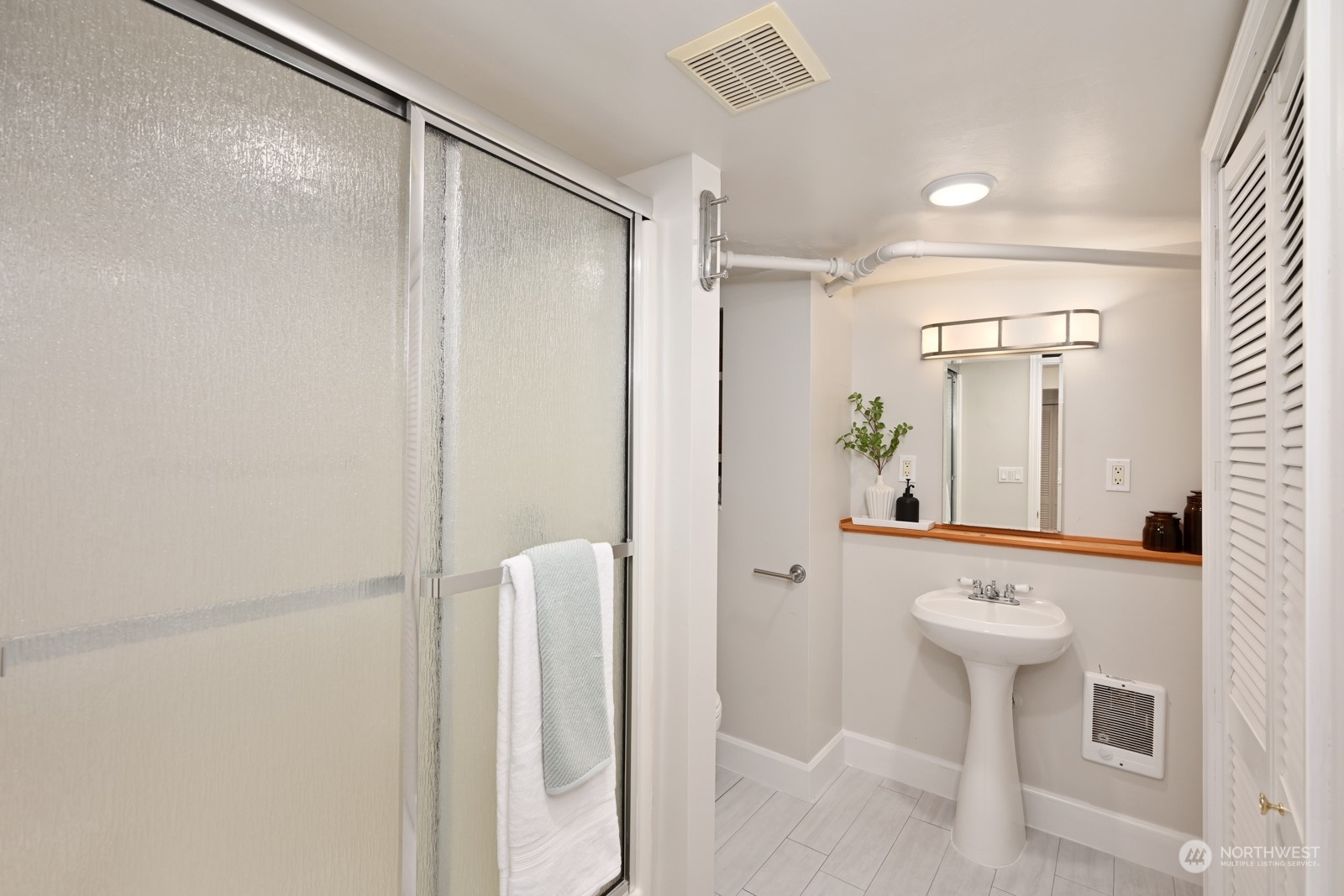 6037 Fauntleroy Way Southwest Seattle, WA 98136 - Photo 30 of 37 a bathroom with a shower a sink and a mirror