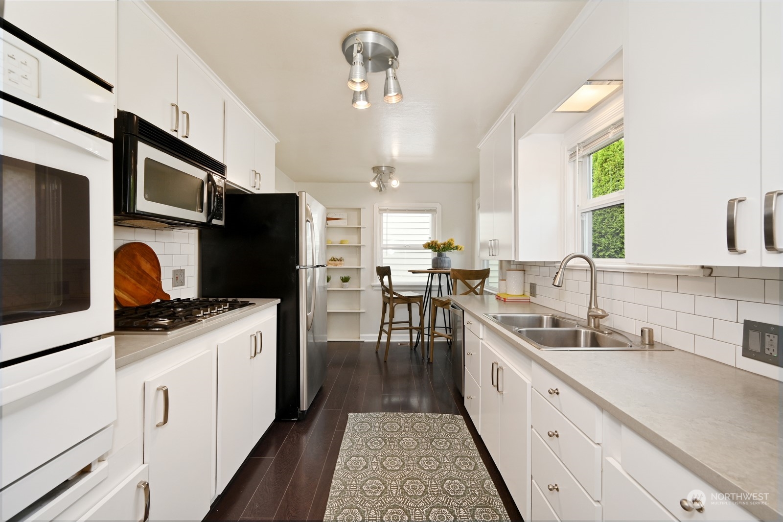 6037 Fauntleroy Way Southwest Seattle, WA 98136 - Photo 10 of 37 a kitchen with stainless steel appliances a stove a sink a stove a microwave a sink a refrigerator dining table and chairs