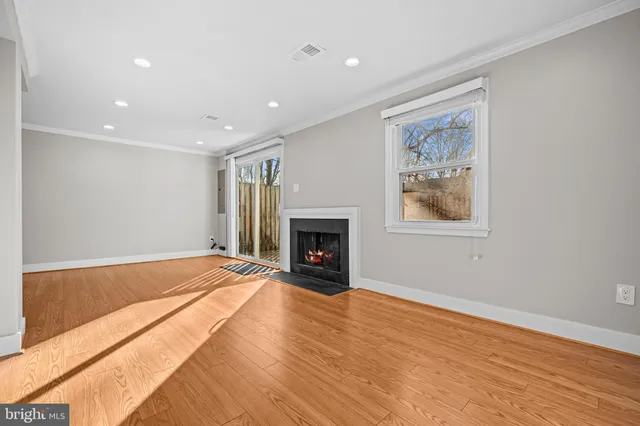 a view of empty room with wooden floor and fireplace