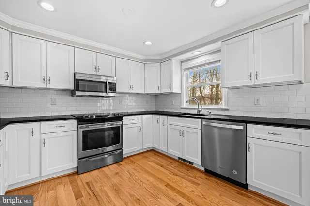 a kitchen with granite countertop cabinets stainless steel appliances and a sink