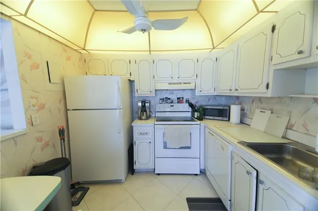 a kitchen with a sink a refrigerator and cabinets