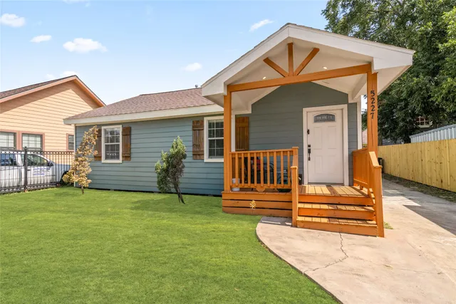 a backyard of a house with table and sofas