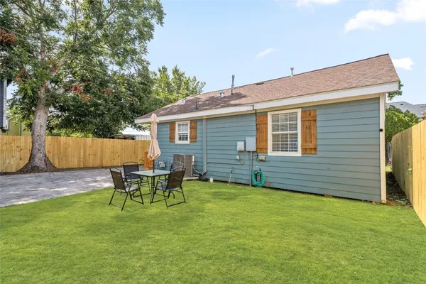 a backyard of a house with table and chairs