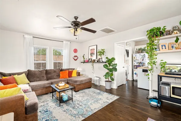 a living room with furniture and a wooden floor