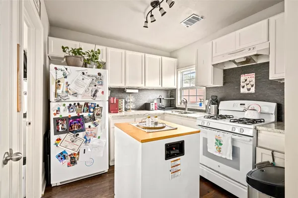 a kitchen with a stove a sink and a refrigerator