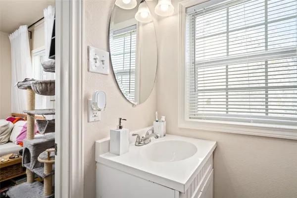 a bathroom with a sink a mirror and a window