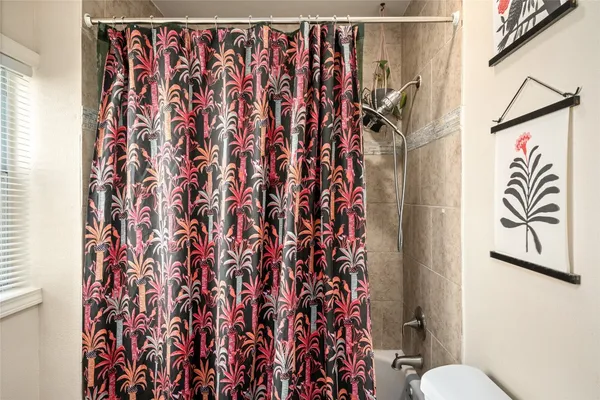a bathroom with a shower curtain and a toilet