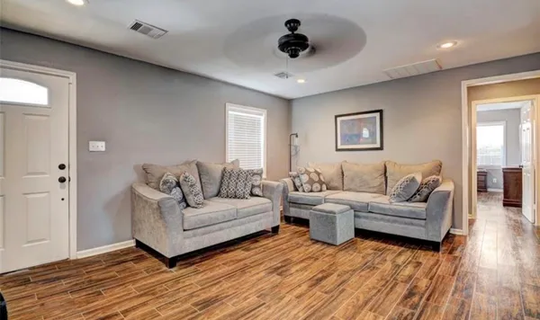 a living room with furniture and a wooden floor