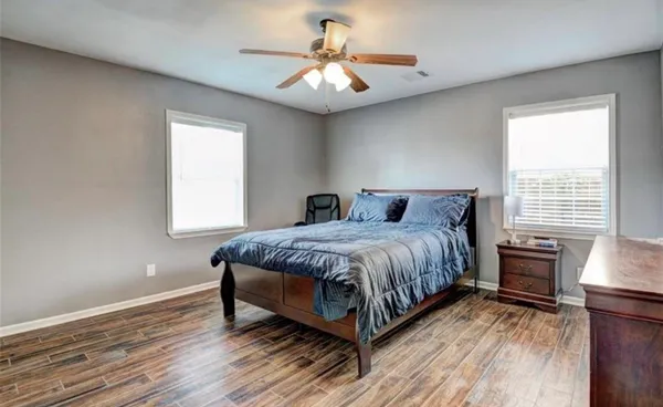 a spacious bedroom with a bed and a chandelier