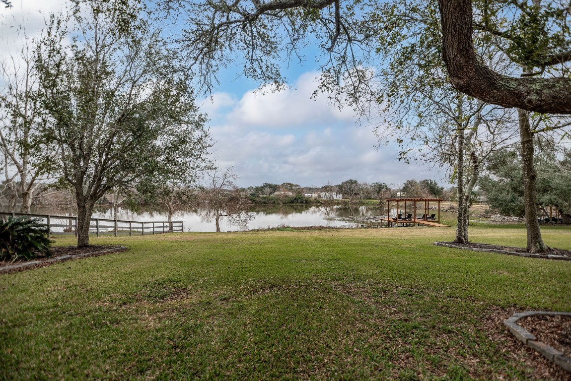 1236 Riverside Drive Palacios, TX 77465 - Photo 17 of 35 a view of a big yard with a fountain and large trees